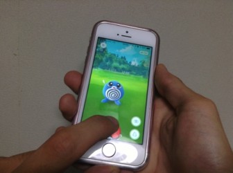 右手で持ちもう片方の手でモンスターボールを投げる